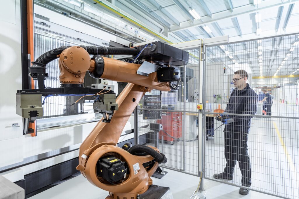 robotics engineer operating robot aided cnc machine